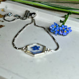 „Handgefertigtes Armband mit echter Vergissmeinnicht-Blume, eingebettet in klares Harz. Verstellbares Edelstahlarmband mit Schiebeverschluss und funkelnden Zirkonia-Endperlen. Symbolträchtiger Schmuck für Frauen – ideal als Geschenk zum Muttertag, Geburtstag oder zur Erinnerung an einen besonderen Menschen.“
