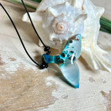 Handgefertigter Walflossen-Anhänger „Flossenklang“ aus Maserholz und türkis-blau-grau-weiß marmoriertem Epoxidharz an verstellbarem Lederband. Maritime Kette als Unikatschmuck für Meeresliebhaber und Wal-Fans, hochwertig poliert, präsentiert vor Muscheldeko und in Schmuckbox von ZeitlosSchmuckDesign.