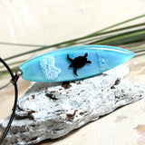 Wellenreiter Surfboard-Necklace – hellblaues Epoxidharz Cabochon mit Schildkröten-Motiv und Wellenoptik, maritimer Unisex-Schmuck