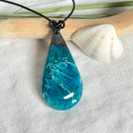 Tropfen Anhänger aus dunklem Maserholz und Epoxidharz in Türkis Blau mit weißer Wellenstruktur am schwarzen Lederband, maritimer Holz Harz Naturschmuck