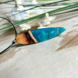 Handgefertigter Surfbrett-Anhänger aus Edelholz & Harz in Türkis mit Metallic-Schimmer. Edelstahlöse, Lederkette 45 + 5 cm Verlängerung.