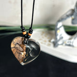 „Handgefertigter Herzanhänger aus Olivenholz und klarem Harz mit echter Pusteblume. Der Anhänger (ca. 3,5 × 3,5 cm) hängt an einem verstellbaren Lederband (23–43 cm) mit Holzperlen. Symbol für Wünsche und Glück, sorgfältig in Handarbeit gegossen, gesägt, geschliffen und poliert. Ein einzigartiger, naturinspirierter Anhänger – ideal als Geschenk oder persönlicher Talisman.“