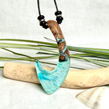 Angelhaken Anhänger aus braunem Maserholz und türkis hellblauem Epoxidharz am schwarzen Lederband mit Onyxperlen, Hei Matau Naturschmuck im Māori Stil