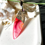 Aurora Flame – fluoreszierender Surfbrett-Anhänger aus Maserholz und leuchtendem Epoxidharz in Rosa, Pink, Orange und Weiß. Der handgefertigte Unikat-Anhänger fluoresziert bei Schwarzlicht in intensiven Farbtönen. Er ist ca. 6,3 x 2 cm groß, wird an einem verstellbaren Lederband (26–45 cm) getragen und ist mit einer silberfarbenen Spacerperle verziert. Ein ausdrucksstarkes Schmuckstück für Menschen mit Persönlichkeit.