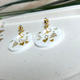 Handgefertigte Ohrringe aus weißem und klarem Harz mit goldenen Weihnachtsmotiven – Sterne, Herzen, Tannenbaum und Zuckerstange. Ohrstecker aus 925 Silber vergoldet, Anhängerschlaufe vergoldet. Größe ca. 37 mm × 25 mm. Leichte, elegante Festtagsohrringe mit warmem Goldglanz und winterlicher Ausstrahlung.