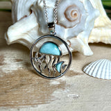 „Sealife“ – runder Anhänger aus rhodiniertem 925 Sterling Silber mit seltenem Larimar und funkelndem Topas. Das maritime Design zeigt eine Qualle, einen Fisch und einen Seestern. Anhängergröße ca. 32 × 26 mm, inklusive 45 cm langer Silberkette (1 mm Stärke). Symbol für die Schönheit und Vielfalt des Ozeans – jedes Stück ein Unikat durch das natürliche Farbspiel des Larimars.