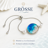 Größenbild des handgefertigten Edelstahl Armbands MEERESZAUBER mit Süßwasserperlen und maritimem Resin Mittelteil, ca. 2 cm Durchmesser, stufenlos verstellbares Armband mit Welle, Muschel, Seestern und Sandoptik.
