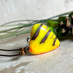 Herz-Anhänger aus Pinienzapfen & Harz, fluoreszierend bei Schwarzlicht. Farben Gelb-Orange-Weiß, Größe 4,2 × 3,8 cm. Lederband verstellbar.