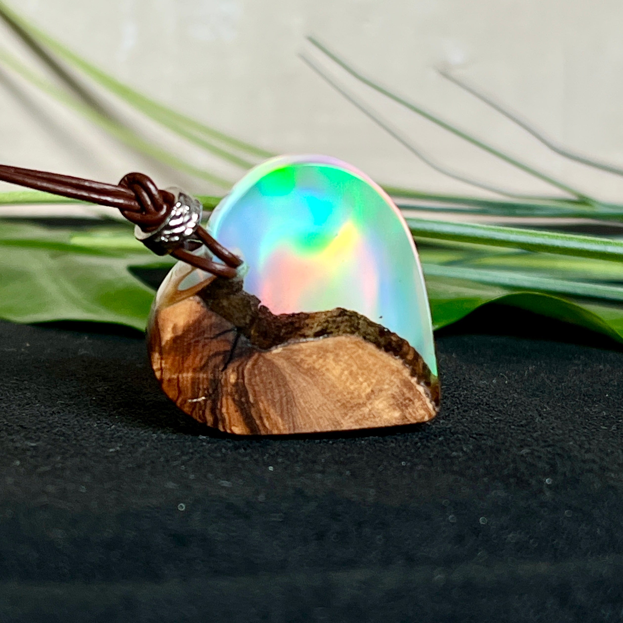 Handgefertigter Herzanhänger aus Olivenholz und schimmerndem Opalharz (Resin Colloidal Imitation Opal) – ein hochwertiges Harz mit feinen, lichtreflektierenden Partikeln, die an echte Opale erinnern. Je nach Licht schimmert der Anhänger in Regenbogenfarben. Mit braunem Lederband und silberfarbener Perle. Jedes Stück ein liebevoll gefertigtes Unikat.