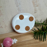 Rosa Teelichthalter aus klarem Epoxidharz, ca. 8 × 6,5 cm, Höhe ca. 4 cm. Im Harz sind kleine rosa Weihnachtskugeln, ein Stern, eine Schneeflocke und rosa Granulat eingegossen. Ovaler Halter für ein Teelicht, Unterseite mit vier runden Korkpads als Möbelschoner. Fotografiert auf Holz mit Tannenzweig und rosa Kugeln als weihnachtlicher Dekohintergrund.