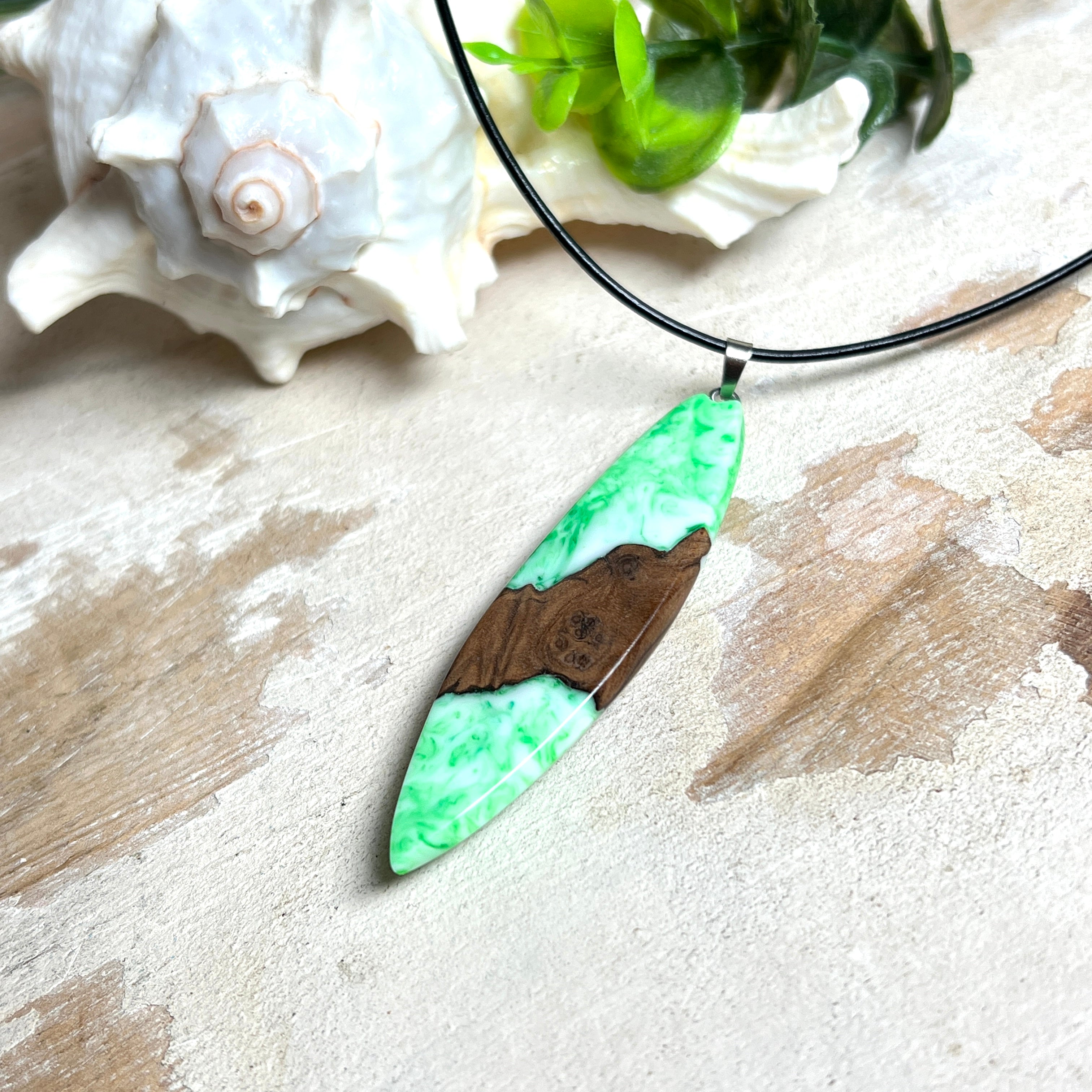 Anhänger aus Nussbaumholz und fluoreszierendem Epoxidharz in Grün-Weiß. Größe ca. 5,8 × 2 cm, Edelstahlöse, Lederkette 45+5 cm. Handgefertigtes Unikat.