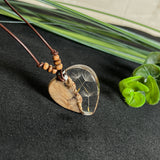Handgefertigter Herzanhänger aus Olivenholz und klarem Harz mit echten Pusteblumen. Der Anhänger misst ca. 3,5 cm, das Lederband ist verstellbar von 23–43 cm und mit kleinen Holzperlen verziert. Ein natürliches Unikat, Symbol für Wünsche und Glück – sorgfältig gegossen, gesägt, geschliffen und poliert.