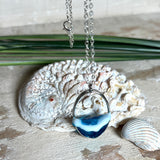 Ovale Halskette „Ocean Crest“ mit 3D-Welle: handgefertigter Harz-Anhänger in Silber-Legierung, Farbverlauf von Tiefblau zu Türkis mit weißer Schaumkrone. Größe ca. 3,9 × 2,3 cm, an einer ca. 56 cm langen versilberten Kette. Glänzende Oberfläche, maritimer Look, Unikat-Handarbeit.