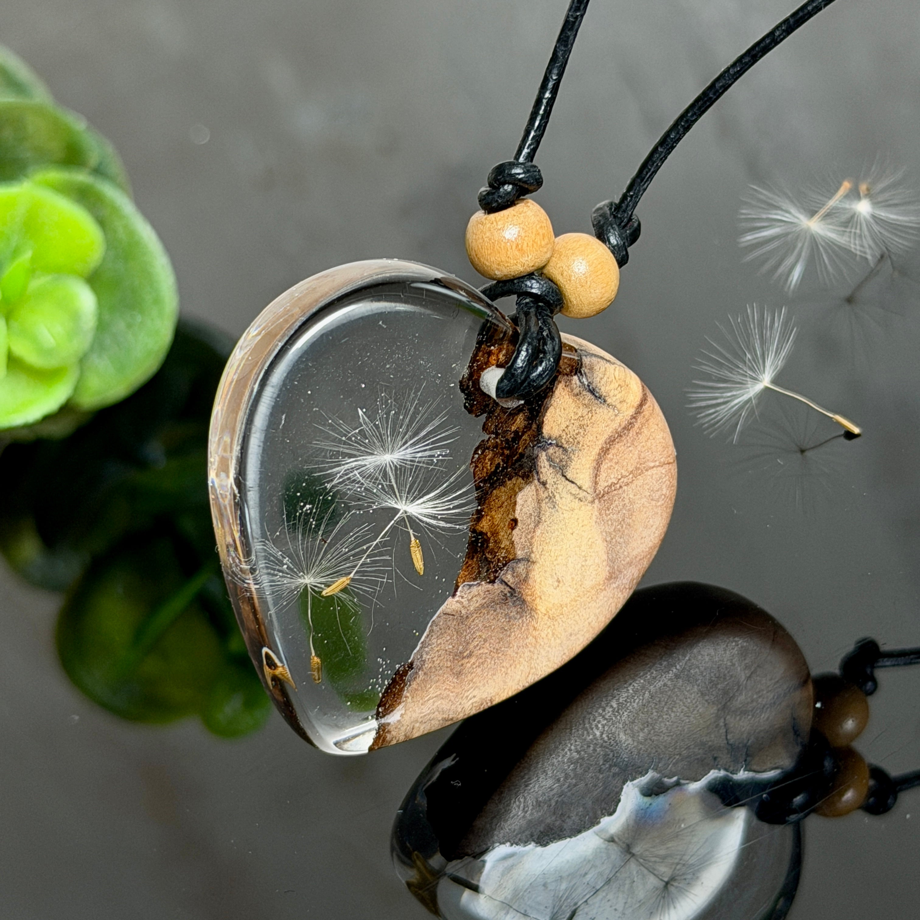 Handgefertigter herzförmiger Anhänger aus Olivenholz und klarem Epoxidharz mit echten schwebenden Pusteblumensamen, an verstellbarer schwarzer Lederkette mit Holzperlen, Unikat 