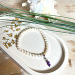 Handgefertigtes Armband „Sea Harmony“ mit schimmernden Süßwasserperlen (Ø ca. 6–7 mm), jede Perle ein Unikat. Auf elastischem Band gefädelt, mit einem filigranen Charmanhänger aus  Amethyst-Perlen, befestigt an einem robusten Edelstahl-Karabiner. Ein Schmuckstück voller Eleganz, maritimer Harmonie und symbolischer Tiefe – ideal als Geschenk oder als stilvolles Accessoire.