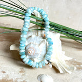Handgefertigtes Armband aus seltenem Larimar mit facettierten, türkis-blauen Edelsteinperlen (Ø ca. 6–7 mm), elastischem Band und einem zarten Süßwasserperlen-Charm an Edelstahlkarabiner. Der wertvolle Larimar, auch „Stein des Atlantis“ genannt, gilt als Edelstein der Ruhe und Meeresverbundenheit.