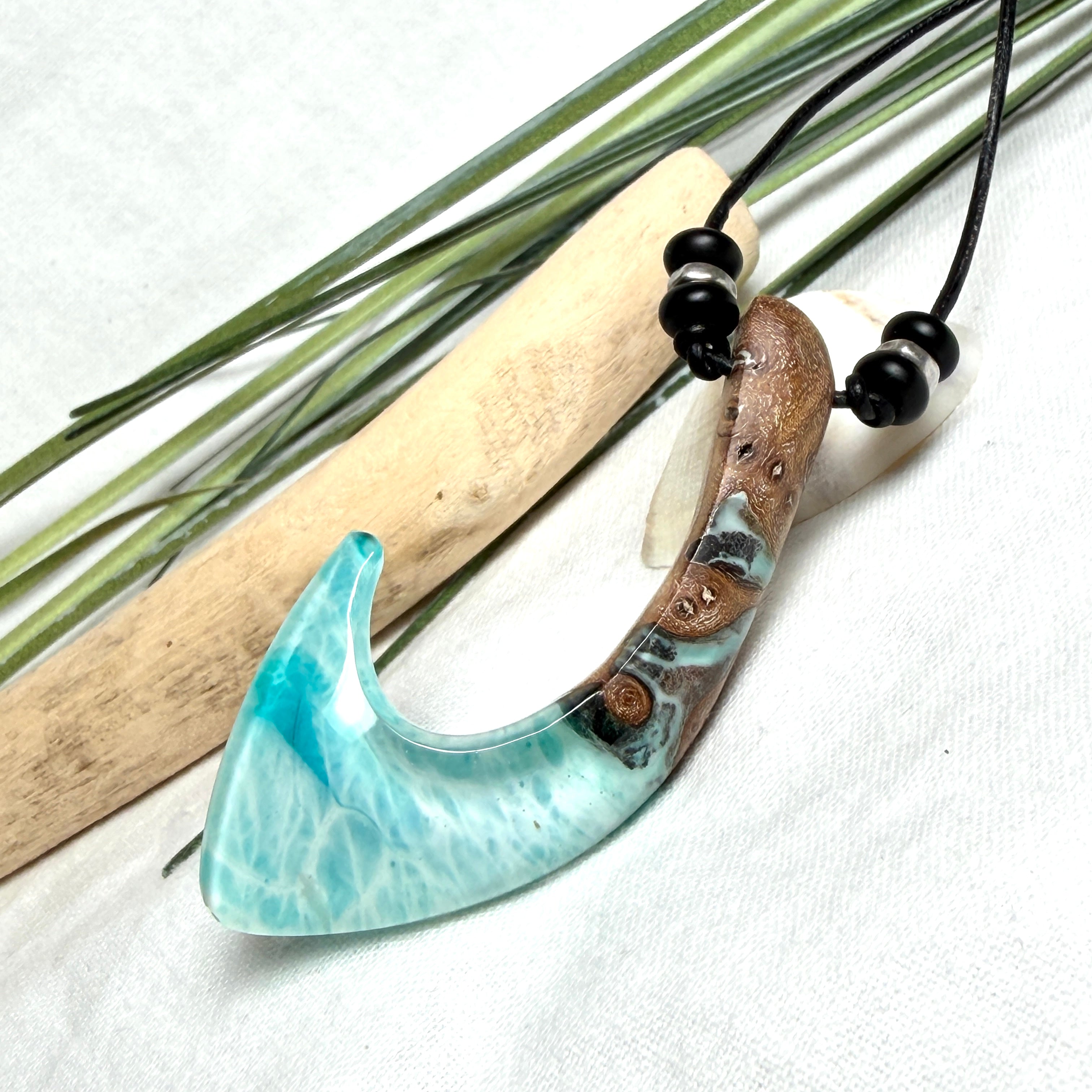 Angelhaken Anhänger aus braunem Maserholz und türkis hellblauem Epoxidharz am schwarzen Lederband mit Onyxperlen, Hei Matau Naturschmuck im Māori Stil