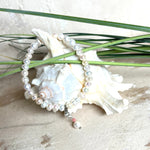Handgefertigtes Armband „Ocean Bloom“ mit echten, schimmernden Süßwasserperlen (Ø ca. 6–7 mm) auf elastischem Band. Jede Perle ist ein Unikat mit natürlicher Form und sanftem Glanz. Highlight: Charmanhänger mit einer Süßwasserperle und einer facettierten Andenopal-Perle, befestigt an einem robusten Edelstahl-Karabiner. Ein Schmuckstück voller Eleganz, Symbolkraft und maritimer Schönheit.