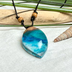 Holz-Harz-Anhänger aus Maserholz und Epoxidharz in Blau, Türkis und Weiß mit Wellenoptik am verstellbaren Lederband mit Holzperlen, handgemachter maritimer Naturschmuck
