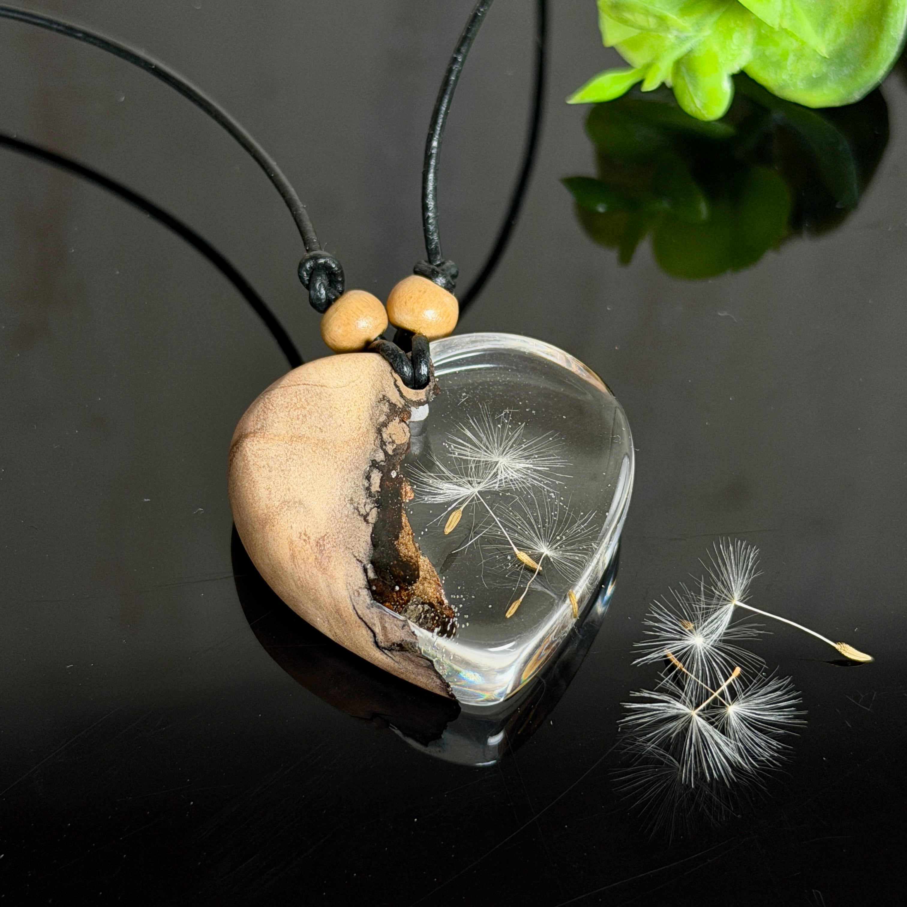 Handgefertigter herzförmiger Anhänger aus Olivenholz und klarem Epoxidharz mit echten schwebenden Pusteblumensamen, an verstellbarer schwarzer Lederkette mit Holzperlen, Unikat 