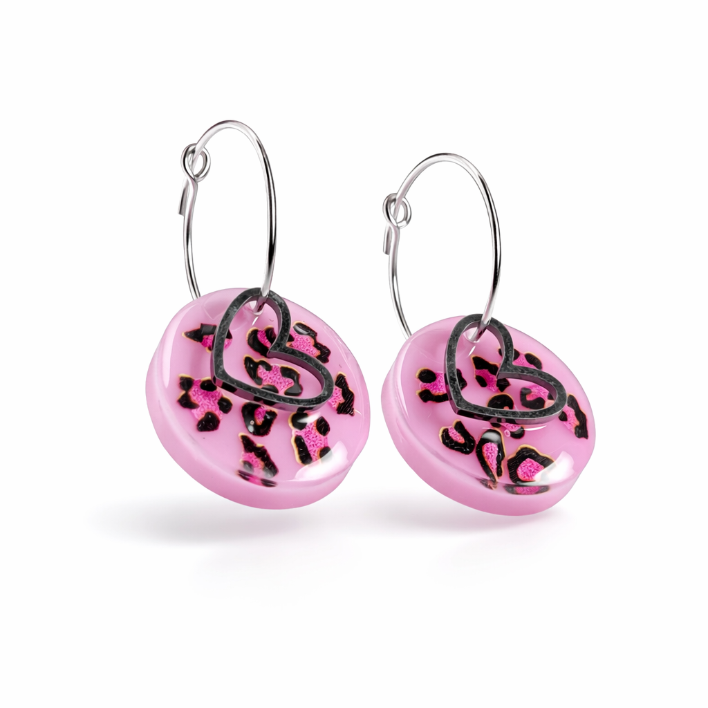 Handgemachte Leo-Creolen aus 925 Silber: Silber-Creolen 16 mm mit rosa Harz-Scheibe (2 cm) im Leoparden-Look und Edelstahl-Herzanhänger. Hängende Ohrringe in Animal-Print Stil, Gesamtlänge ca. 3,5 cm. Resin-Ohrringe für Alltag, Party oder Festival, femininer Statement-Schmuck in Rosa/Pink mit silberfarbenen Metallteilen. Einzeln gegossen, jedes Paar ein Unikat; leichte Abweichungen im Muster, Farbspiel und kleine Luftbläschen sind möglich und typisch für Handarbeit.