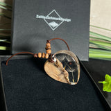 Handgefertigter Herzanhänger aus Olivenholz und klarem Harz mit echten Pusteblumen. Der Anhänger misst ca. 3,5 cm, das Lederband ist verstellbar von 23–43 cm und mit kleinen Holzperlen verziert. Ein natürliches Unikat, Symbol für Wünsche und Glück – sorgfältig gegossen, gesägt, geschliffen und poliert.