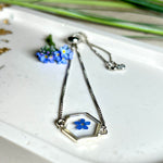 „Handgefertigtes Armband mit echter Vergissmeinnicht-Blume, eingebettet in klares Harz. Verstellbares Edelstahlarmband mit Schiebeverschluss und funkelnden Zirkonia-Endperlen. Symbolträchtiger Schmuck für Frauen – ideal als Geschenk zum Muttertag, Geburtstag oder zur Erinnerung an einen besonderen Menschen.“
