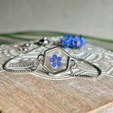 „Handgefertigtes Armband mit echter Vergissmeinnicht-Blume, eingebettet in klares Harz. Verstellbares Edelstahlarmband mit Schiebeverschluss und funkelnden Zirkonia-Endperlen. Symbolträchtiger Schmuck für Frauen – ideal als Geschenk zum Muttertag, Geburtstag oder zur Erinnerung an einen besonderen Menschen.“
