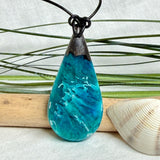 Tropfen Anhänger aus dunklem Maserholz und Epoxidharz in Türkis Blau mit weißer Wellenstruktur am schwarzen Lederband, maritimer Holz Harz Naturschmuck