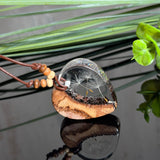 Herzanhänger „Pusteblumenzauber“ aus naturbelassenem Rebholz und klarem Epoxidharz mit schwebenden Pusteblumensamen. Dunkelbraunes, verstellbares Lederband mit kleinen Holzperlen, Anhänger ca. 3,5 × 3,5 cm. Handgefertigtes Unikat von ZeitlosSchmuckDesign.