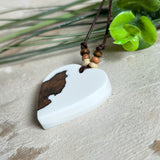Herzanhänger „Pure Heart“ aus Maserholz und weißem Epoxidharz. Handgefertigtes Unikat mit kontrastreichem Design – die natürliche Maserung des Holzes trifft auf die klare Reinheit von Weiß. Größe ca. 3,5 × 3,5 cm. Verstellbares Lederband (23–41 cm) mit Holzperlen. Ein edles Schmuckstück, inspiriert von Natur und Liebe.
