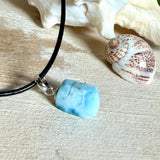 Larimar Freeform Anhänger mit rhodinierter Silberöse an schwarzer Lederkette. Der seltene, kostbare Larimar („Atlantisstein“) zeigt ein lebendiges Muster aus Türkis- und Weißtönen. Beidseitig tragbar, Steingröße ca. 2 x 1 cm, Lederkette 45 cm mit Edelstahl-Karabiner und 5 cm Verlängerung. Natürlicher, maritimer Unikatschmuck.