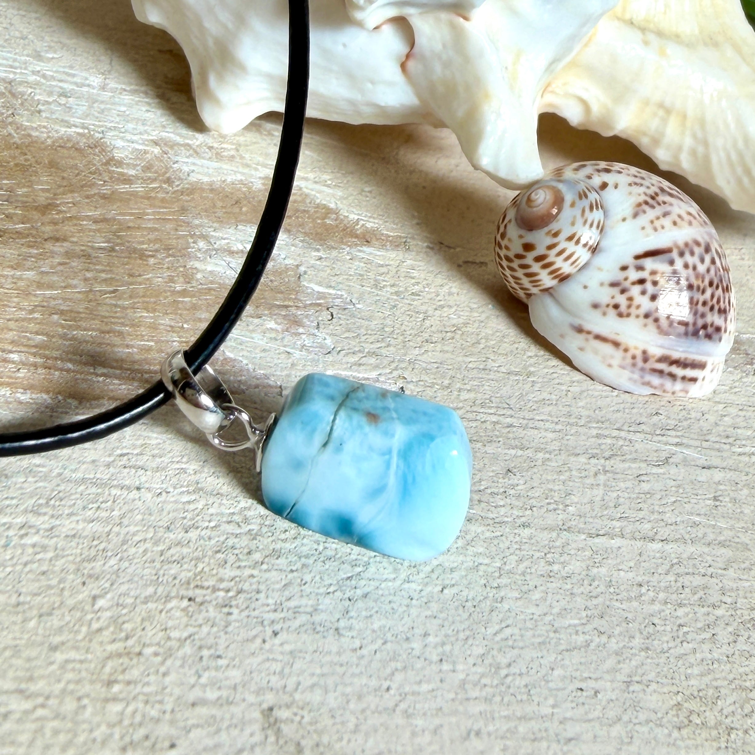 Larimar Freeform Anhänger mit rhodinierter Silberöse an schwarzer Lederkette. Der seltene, kostbare Larimar („Atlantisstein“) zeigt ein lebendiges Muster aus Türkis- und Weißtönen. Beidseitig tragbar, Steingröße ca. 2 x 1 cm, Lederkette 45 cm mit Edelstahl-Karabiner und 5 cm Verlängerung. Natürlicher, maritimer Unikatschmuck.