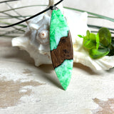 Anhänger aus Nussbaumholz und fluoreszierendem Epoxidharz in Grün-Weiß. Größe ca. 5,8 × 2 cm, Edelstahlöse, Lederkette 45+5 cm. Handgefertigtes Unikat.