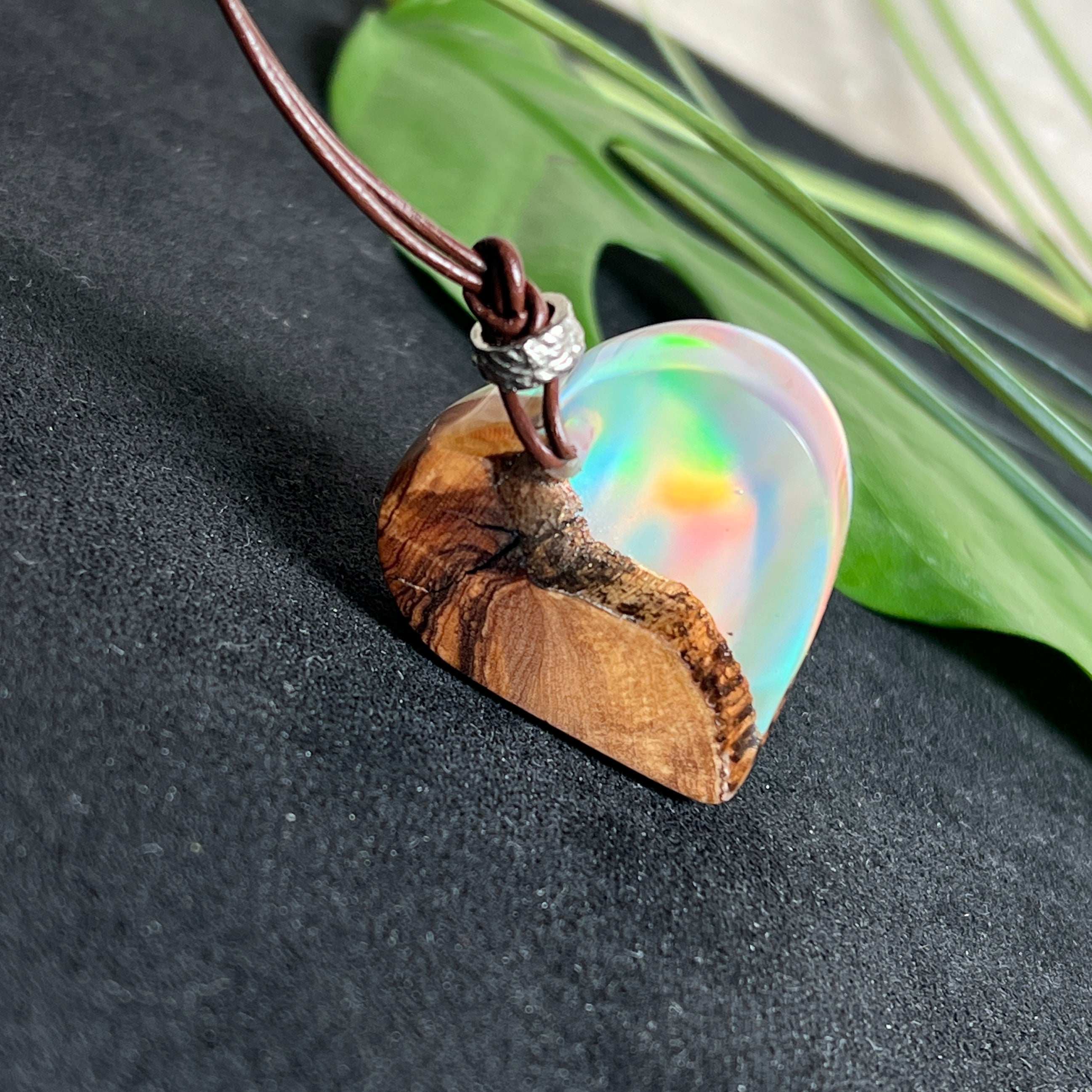 Handgefertigter Herzanhänger aus Olivenholz und schimmerndem Opalharz (Resin Colloidal Imitation Opal) – ein hochwertiges Harz mit feinen, lichtreflektierenden Partikeln, die an echte Opale erinnern. Je nach Licht schimmert der Anhänger in Regenbogenfarben. Mit braunem Lederband und silberfarbener Perle. Jedes Stück ein liebevoll gefertigtes Unikat.