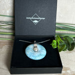 
Echter Larimar-Donut (42 mm) mit Süßwasserperle, gefasst in rhodiniertem 925 Sterlingsilber. Mit 45 cm langer, rhodinierter Silberkette. Selten, edel & handgefertigt – inspiriert vom Blau der Karibik.