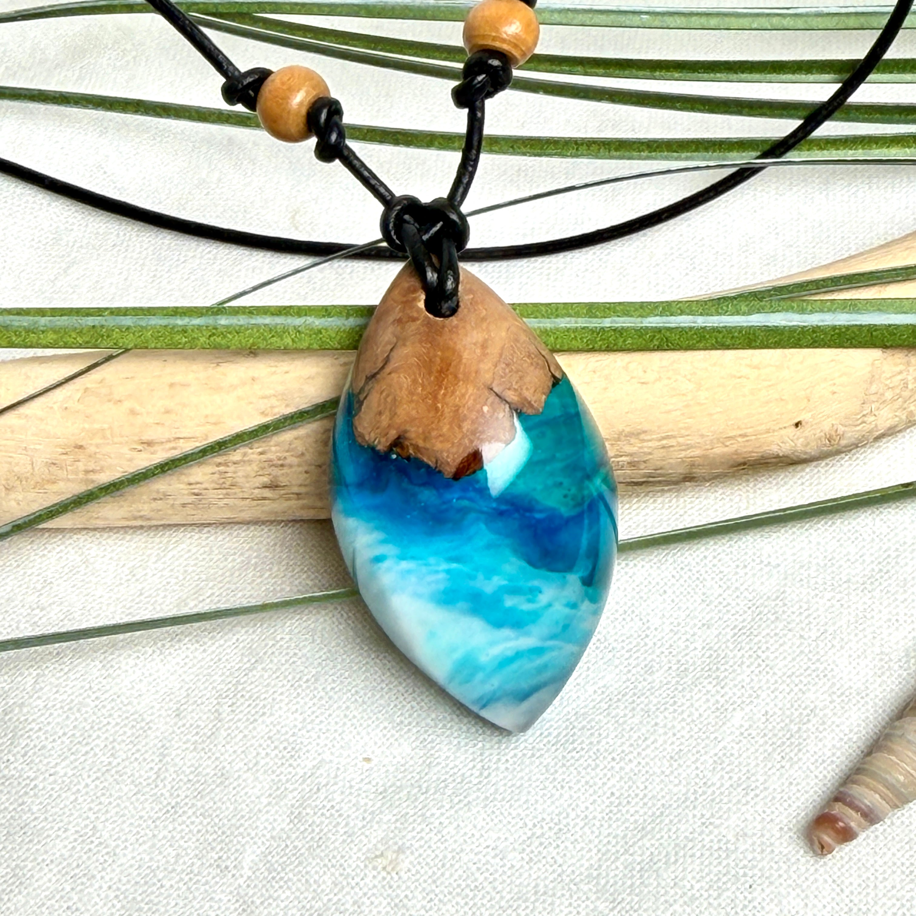 Holz-Harz-Anhänger aus Maserholz und Epoxidharz in Blau, Türkis und Weiß mit Wellenoptik am verstellbaren Lederband mit Holzperlen, handgemachter maritimer Naturschmuck