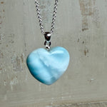 Larimar-Herzanhänger in zarten Blau- und Weißtönen, beidseitig poliert, an einer feinen platinrhodinierten 925 Silber Ankerkette mit 1 mm Stärke und 45 cm Länge. Das seltene Larimar-Herz aus der Dominikanischen Republik erinnert optisch an Meer und Himmel .