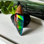 Der handgefertigte Anhänger „Celestial Flame“ kombiniert warmes Olivenholz mit glasklarem Harz und irisierendem Opal. Das einzigartige Farbspiel erinnert an Polarlichter und verleiht dem Schmuckstück eine mystische Tiefe. Die Oberfläche ist glatt poliert, der Anhänger wird an einem verstellbaren Lederband getragen – ein ausdrucksstarkes Unikat für alle, die Naturmaterialien und kreative Farben lieben.
