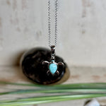 Feine Schildkröten-Kette aus rhodiniertem 925 Silber. Im Panzer des Anhängers liegt ein tropfenförmiger Larimar in hellem Blau. Der Anhänger ist ca. 22 x 18 mm groß und hängt an einer 45 cm langen, 1 mm starken Silberkette.