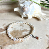Handgefertigtes Armband „Ocean Bloom“ mit echten, schimmernden Süßwasserperlen (Ø ca. 6–7 mm) auf elastischem Band. Jede Perle ist ein Unikat mit natürlicher Form und sanftem Glanz. Highlight: Charmanhänger mit einer Süßwasserperle und einer facettierten Andenopal-Perle, befestigt an einem robusten Edelstahl-Karabiner. Ein Schmuckstück voller Eleganz, Symbolkraft und maritimer Schönheit.