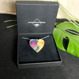 Handgefertigter Herzanhänger aus Maserholz und schimmerndem Opalharz, inspiriert von den Farben der Aurora Borealis. Das Holz zeigt eine feine Maserung, das Harz leuchtet in Rosa-, Blau- und Violetttönen. Mit zarter 925 Silber-Ankerkette (1 mm stark, 45 cm lang) und Silberöse. Ein edles Unikat in liebevoller Handarbeit gefertigt.