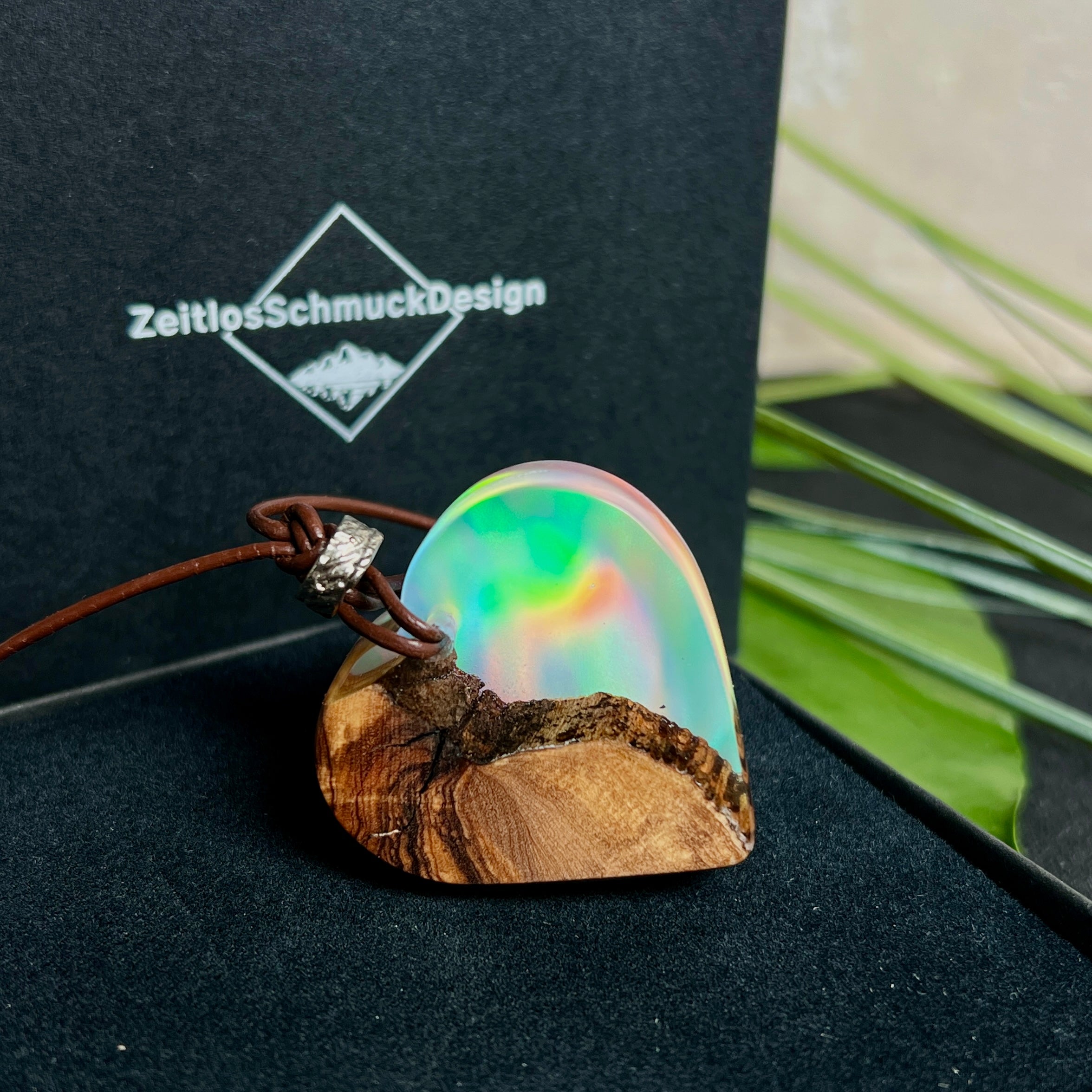 Handgefertigter Herzanhänger aus Olivenholz und schimmerndem Opalharz (Resin Colloidal Imitation Opal) – ein hochwertiges Harz mit feinen, lichtreflektierenden Partikeln, die an echte Opale erinnern. Je nach Licht schimmert der Anhänger in Regenbogenfarben. Mit braunem Lederband und silberfarbener Perle. Jedes Stück ein liebevoll gefertigtes Unikat.