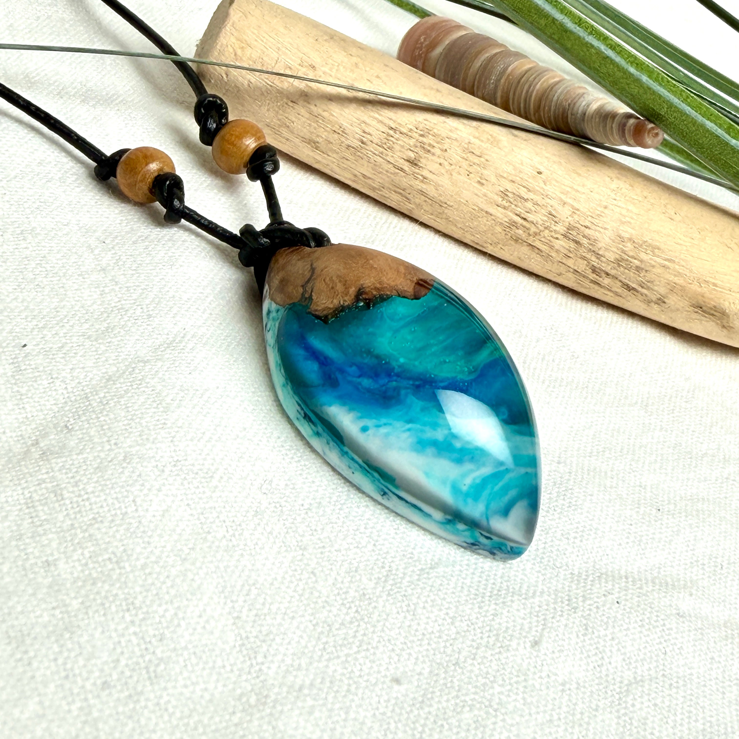 Holz-Harz-Anhänger aus Maserholz und Epoxidharz in Blau, Türkis und Weiß mit Wellenoptik am verstellbaren Lederband mit Holzperlen, handgemachter maritimer Naturschmuck