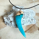 Handgefertigter Anhänger aus Edelholz und transparent-türkisblauem und weißen Epoxidharz, glatt poliert. Größe ca. 6,5 × 2,0 cm. Mit Edelstahlöse an schwarzer Lederkette (45 cm + 5 cm Edelstahl-Verlängerung, Karabiner). Moderner, unisex tragbarer Schmuck mit natürlicher Holzmaserung; kleine Lufteinschlüsse sind charakteristisch.