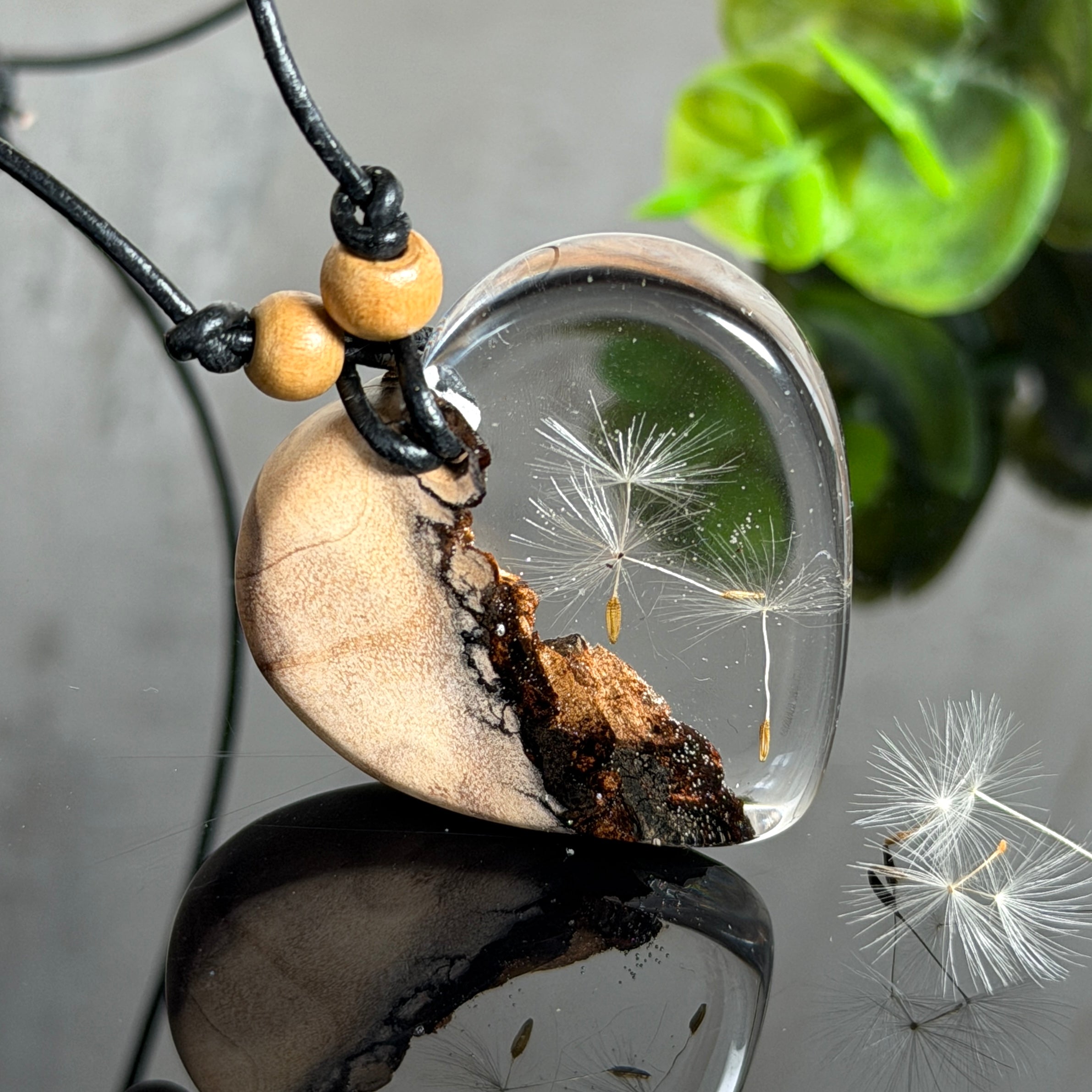 Handgefertigter herzförmiger Anhänger aus Olivenholz und klarem Epoxidharz mit echten schwebenden Pusteblumensamen, an verstellbarer schwarzer Lederkette mit Holzperlen, Unikat 