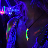 KI-generiertes Tragebild auf einem Festival unter Schwarzlicht: handgefertigter Surfbrett-Anhänger „Tropical Glow“ aus Rebholz und fluoreszierendem Epoxidharz in Grün, Orange, Türkis und Weiß, gerade hängend an schwarzer Lederkette, leuchtender Unikat-Schmuck im Neon-UV-Licht.