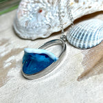 Ovale Halskette „Ocean Crest“ mit 3D-Welle: handgefertigter Harz-Anhänger in Silber-Legierung, Farbverlauf von Tiefblau zu Türkis mit weißer Schaumkrone. Größe ca. 3,9 × 2,3 cm, an einer ca. 56 cm langen versilberten Kette. Glänzende Oberfläche, maritimer Look, Unikat-Handarbeit.