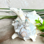 Edle „Ocean Star“ Ohrringe aus 925 Sterling Silber mit Seestern-Anhängern (18 × 17 mm), verziert mit einer aquablauen Apatitperle und funkelndem Zirkonia. Länge getragen: 45 mm. Maritime Schmuckstücke, die das Funkeln des Meeres einfangen – elegant, hochwertig und ein ideales Geschenk für Meeresliebhaber und Sommerträume.