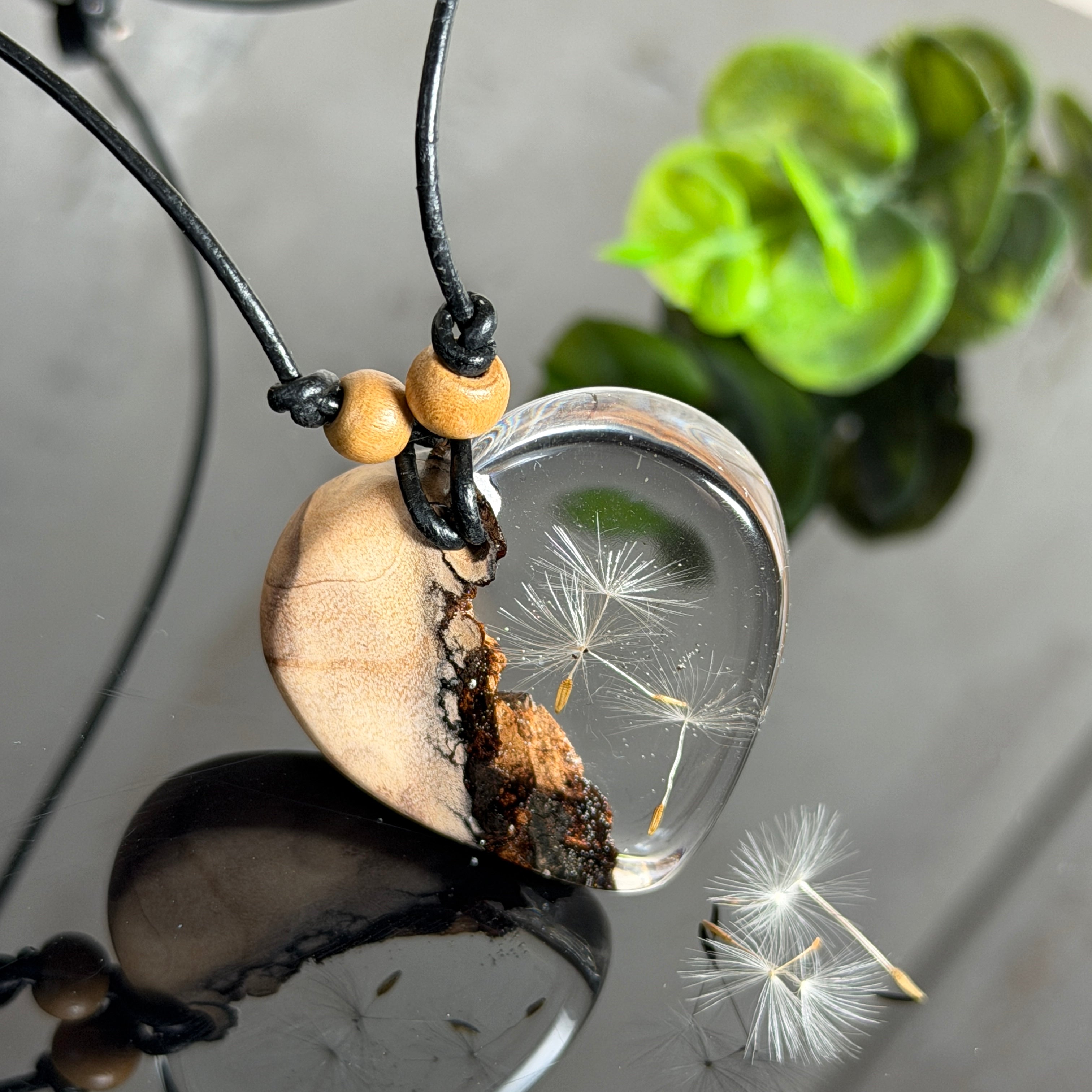 Handgefertigter herzförmiger Anhänger aus Olivenholz und klarem Epoxidharz mit echten schwebenden Pusteblumensamen, an verstellbarer schwarzer Lederkette mit Holzperlen, Unikat 